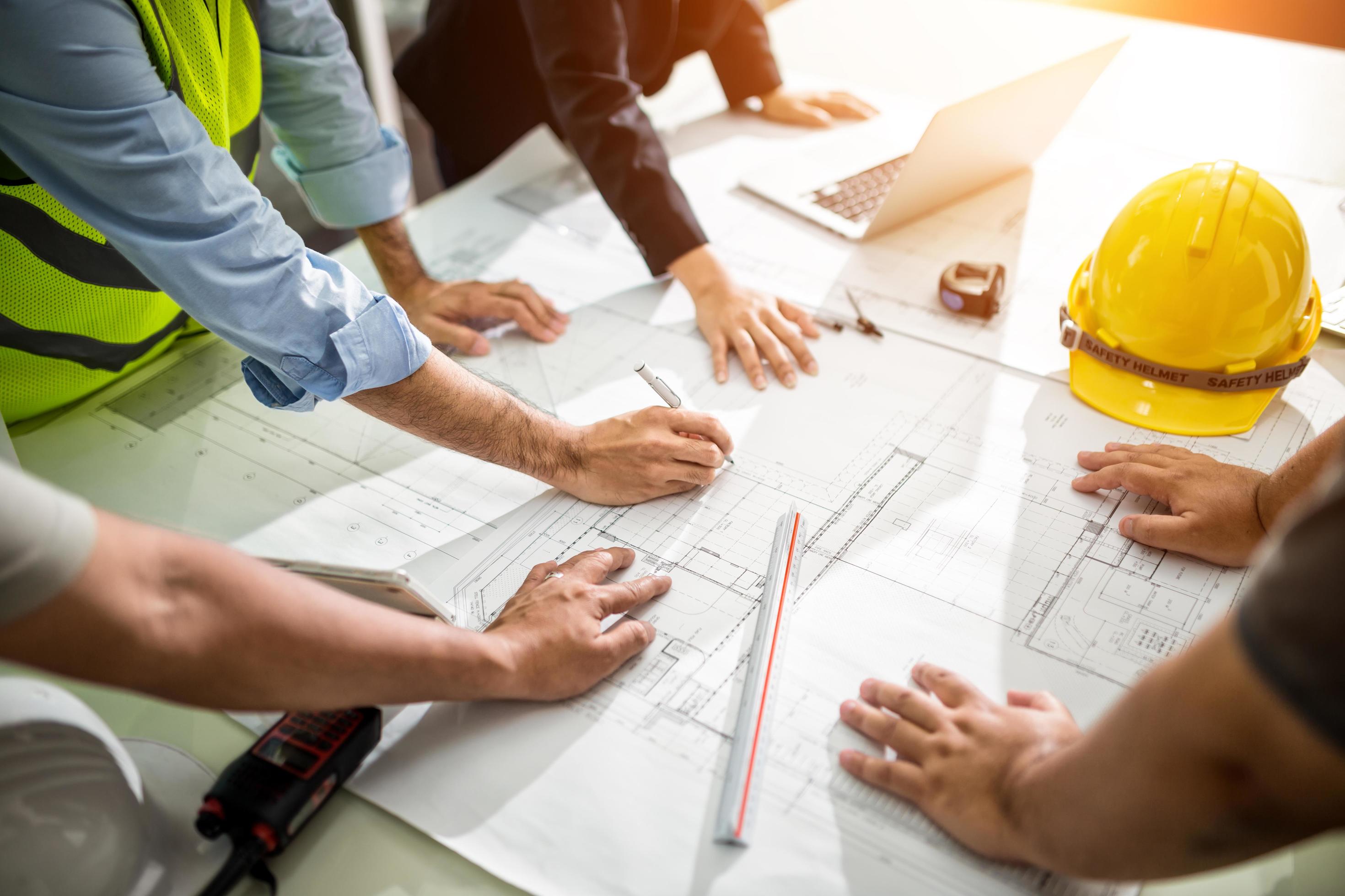 team of engineers drawing graphic planning of interior creation project cooperating with talented teachers giving advice working concept free photo